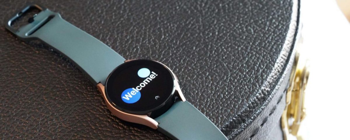 El Samsung Galaxy Watch 4 descansa sobre un estuche de cuero negro que muestra la pantalla de bienvenida del reloj.